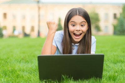 Excited child using computer outside