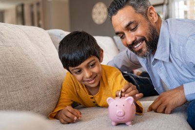 Happy father and son with piggy bank