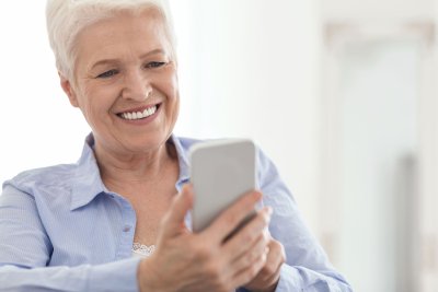 white haired woman using mobile phone